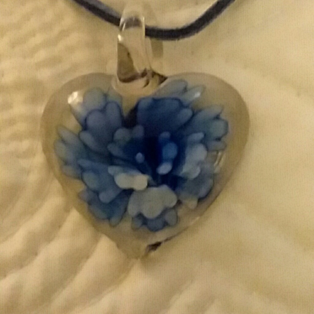 Flower in glass heart necklace on leather.